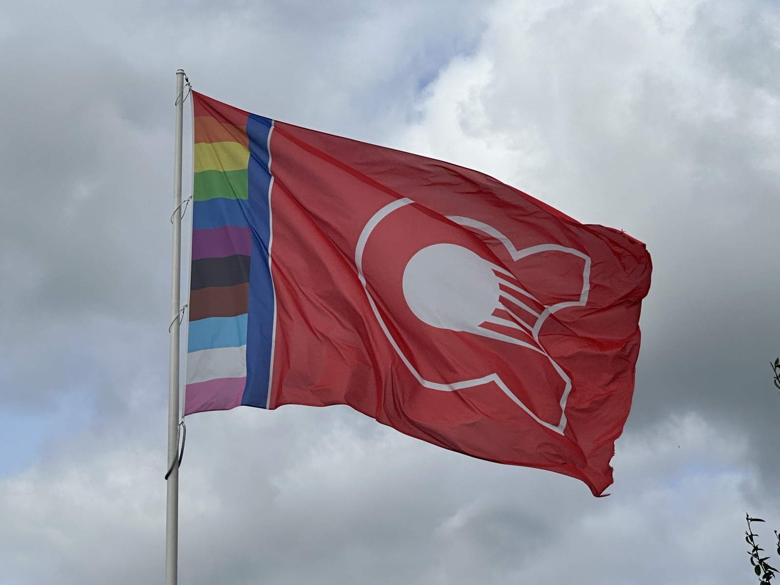 De clubvlag van HC AthenA wappert tegen een bewolkte lucht