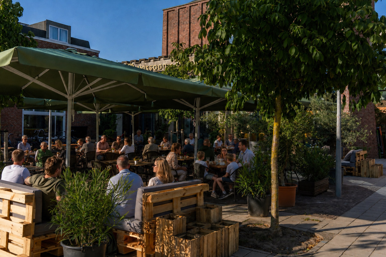 Het terras van Brasserie Lenny op het plein aan de James Wattstraat, met groene parasols en de voormalige Christus Koningkerk op de achtergrond