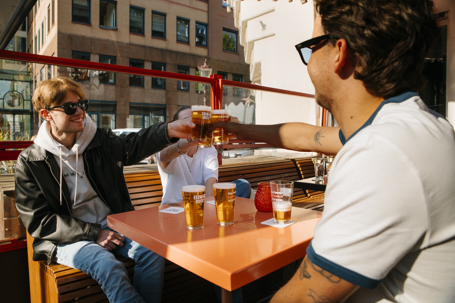 Bezoekers proosten met bierglazen van De Eeuwige Jeugd op het terras