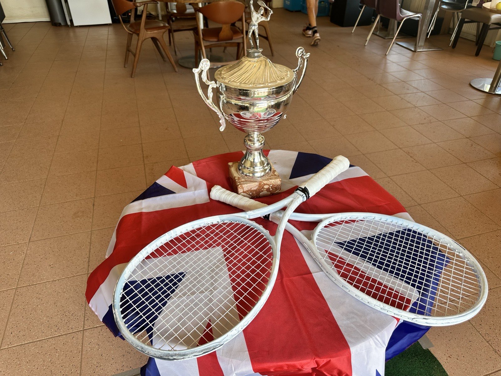De wisselbeker en witte rackets op de Union Jack