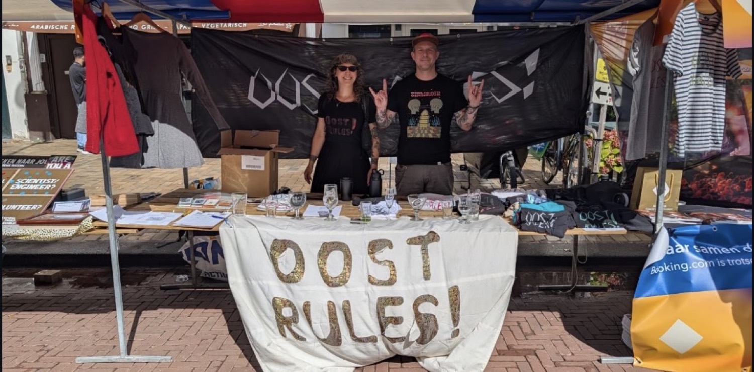 Twee vrijwilligers van Oost Rules bij hun kraam op het Indische Buurt Festival