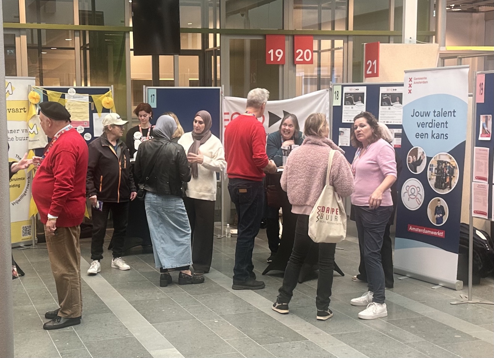 Bezoekers in gesprek bij informatiekramen tijdens Kracht van Oost vorig jaar in het stadsdeelkantoor