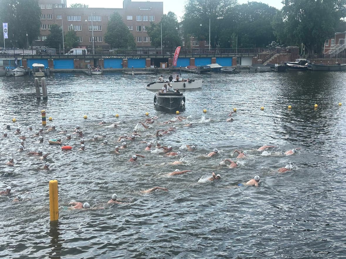 Honderden zwemmers in de Amstel tijdens de tiende editie van LoveSwim