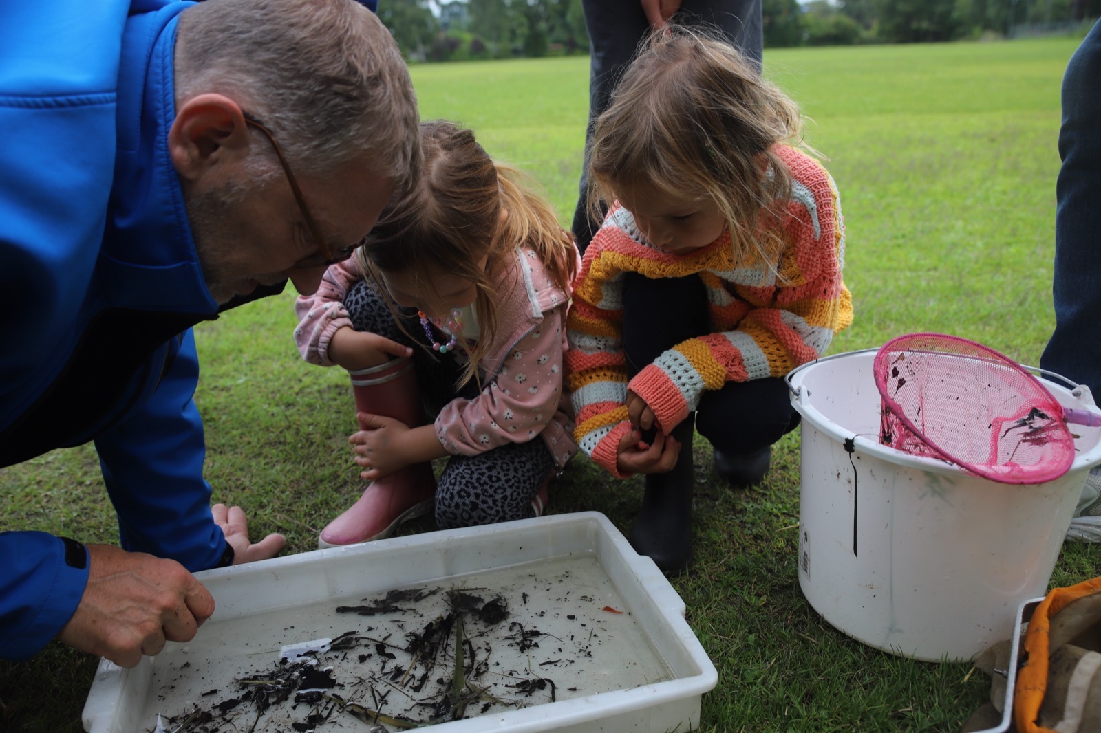 Vrijwilliger laat kinderen tijdens de workshop waterleven zien wat er in de sloot leeft