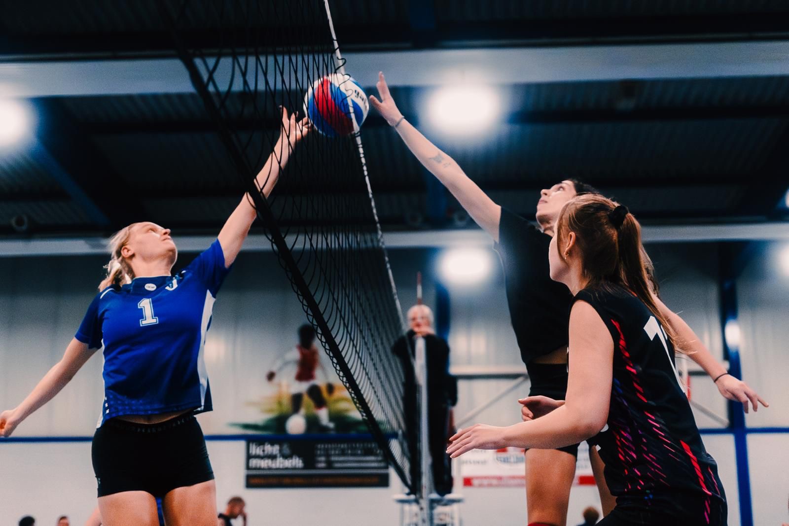Netzo-volleybalsters in duel bij het net tijdens een wedstrijd