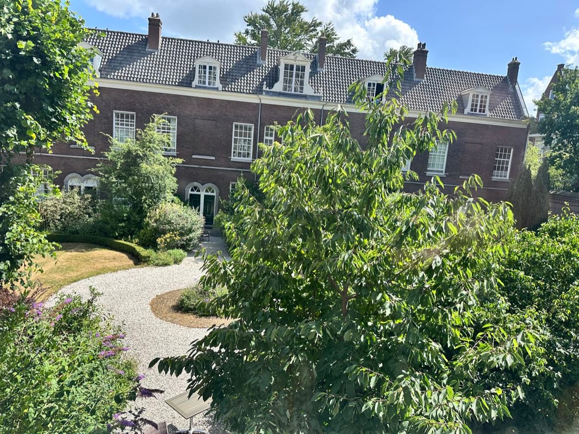 Achter de gesloten poort van het Occo Hofje ligt een stille wereld