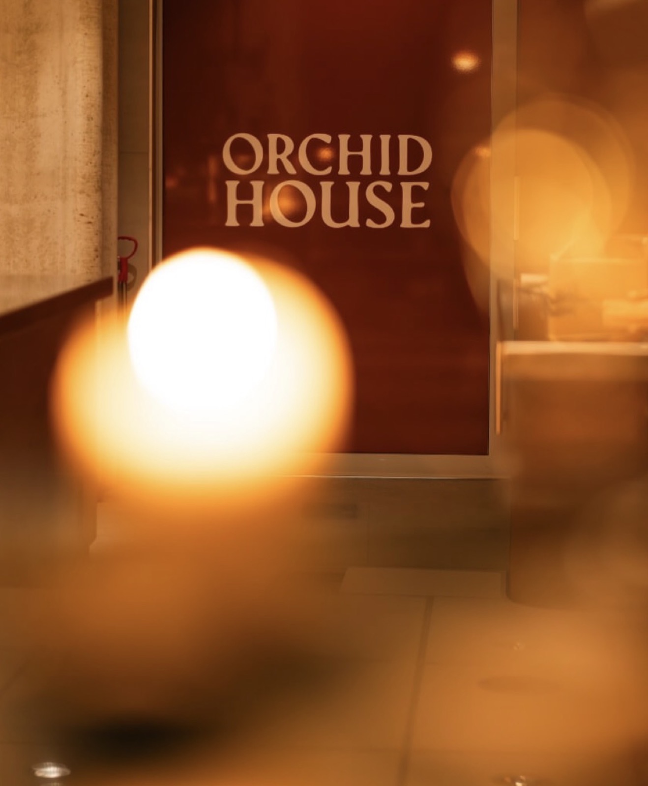 De entree van Orchid House, sfeervol verlicht