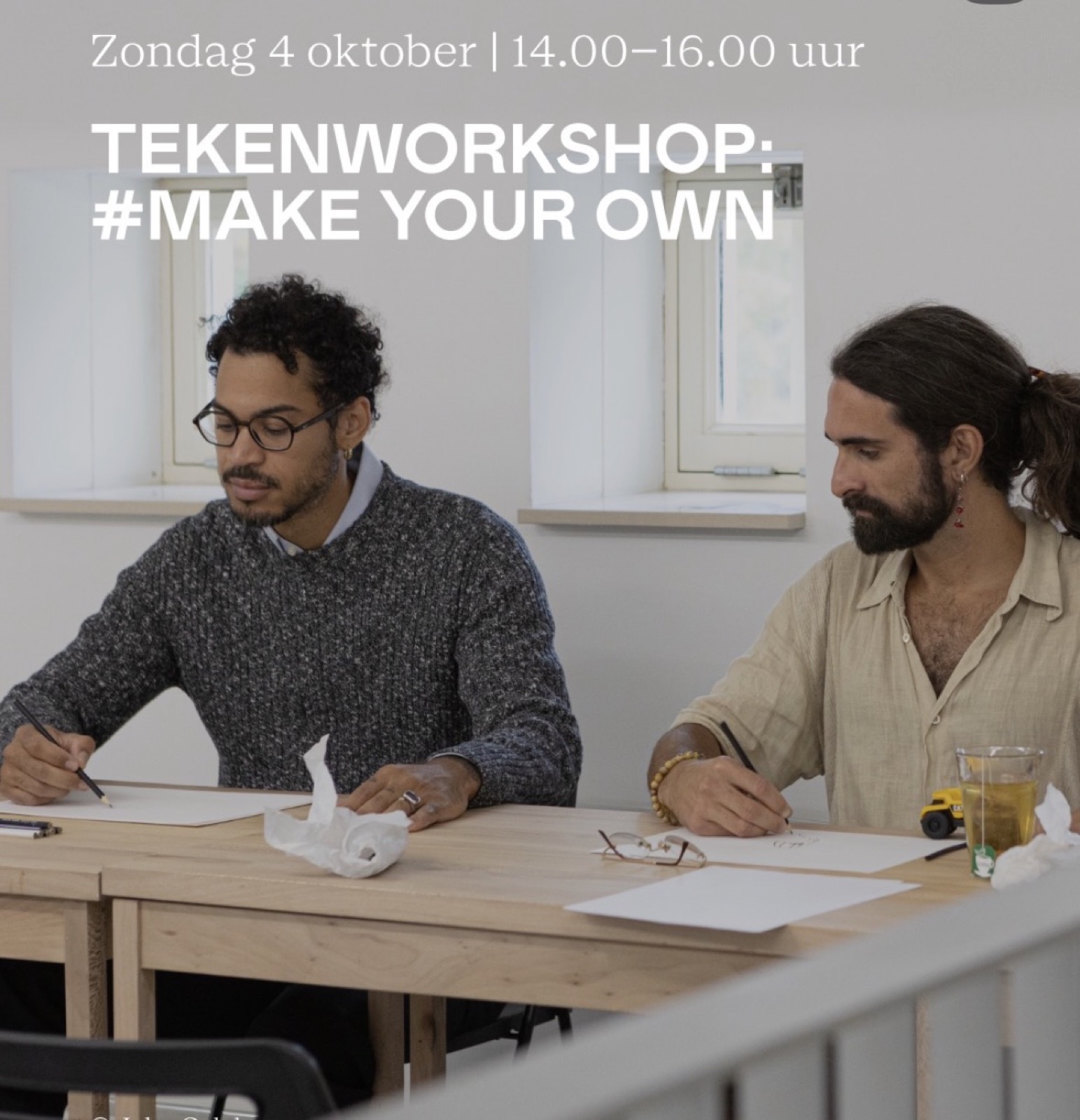 Deelnemers aan de tekenworkshop #Make Your Own tekenen aan een tafel