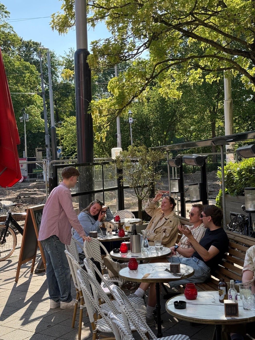 Zomerse drukte op het terras onder de boom