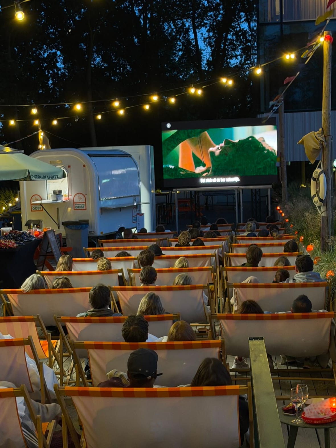 Volle rijen strandstoelen tijdens een uitverkochte Rooftop Movie Night bij Strand van Oost