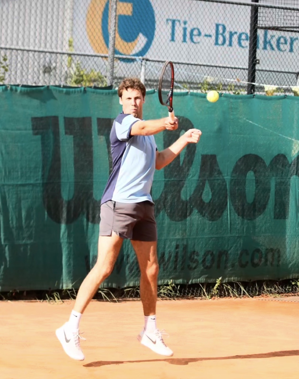 Een deelnemer slaat een forehand tijdens een wedstrijd op het gravel van Tie-Breakers