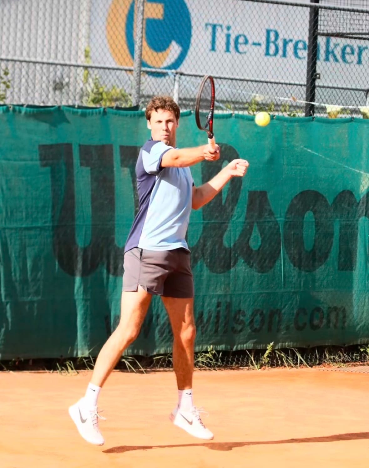 Een deelnemer slaat een forehand tijdens een wedstrijd op het gravel van Tie-Breakers