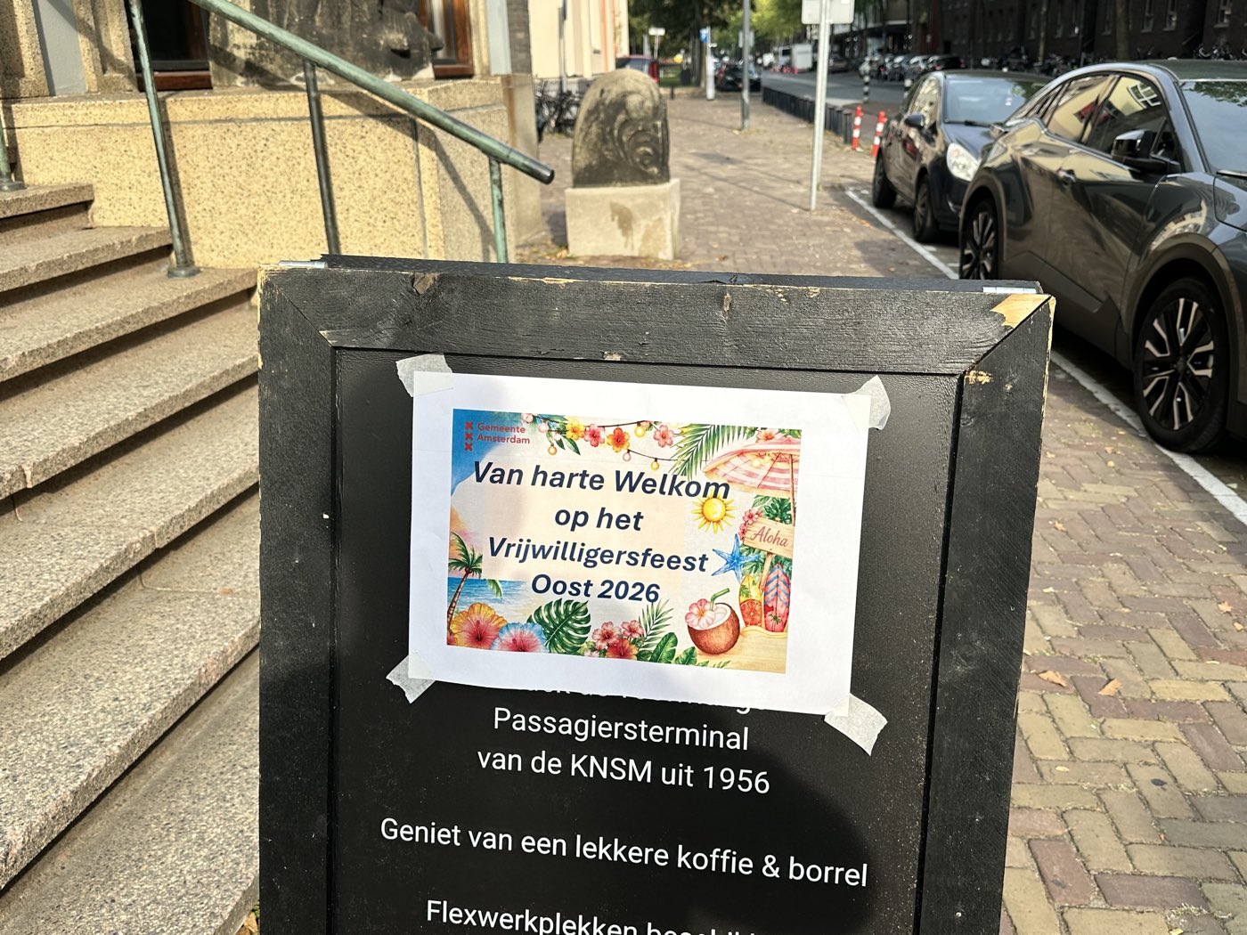 Aankondigingsbord bij de ingang: ‘Van harte welkom op het Vrijwilligersfeest Oost 2026’, in de voormalige passagiersterminal van de KNSM uit 1956