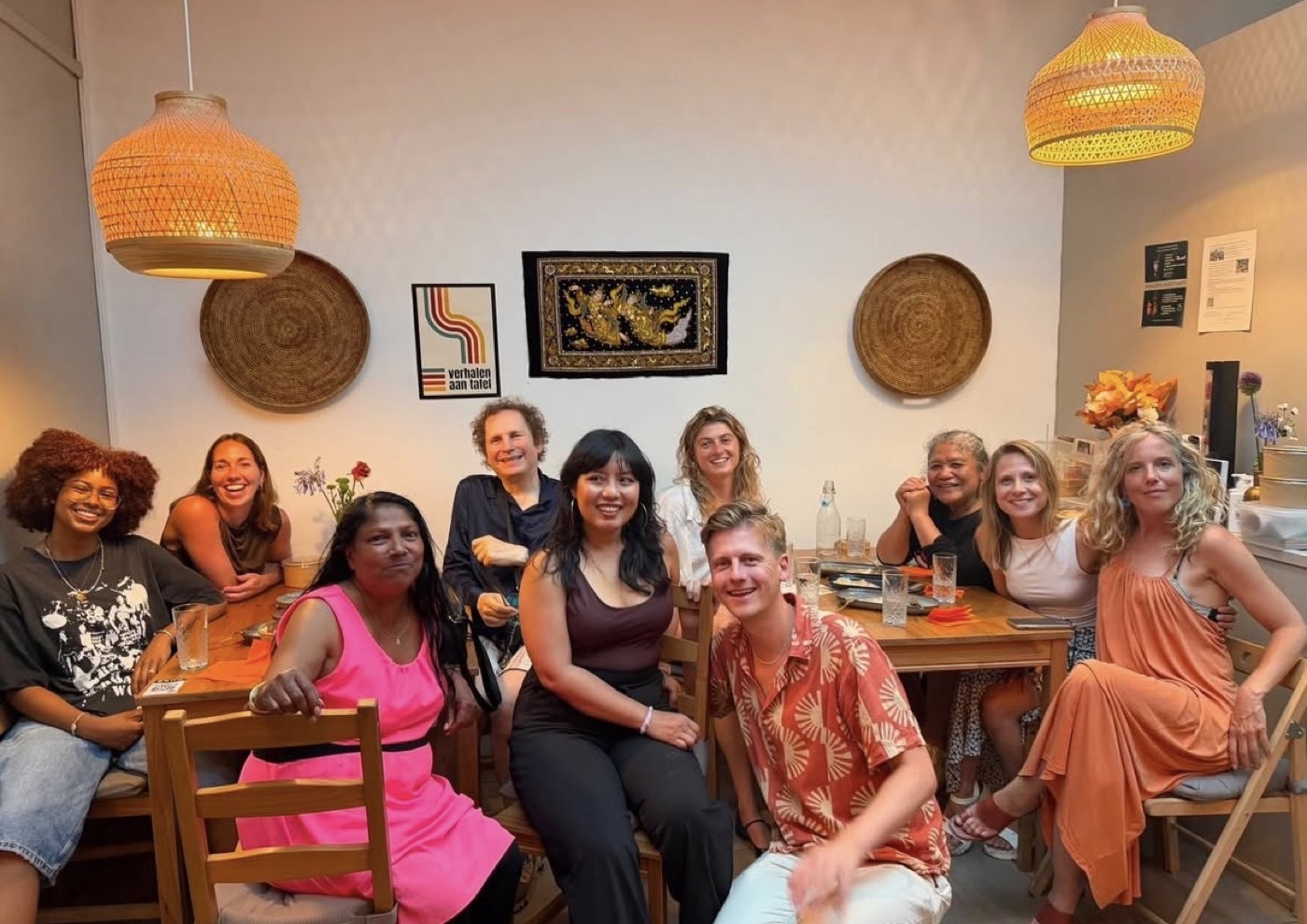 Deelnemers van Verhalen aan Tafel zitten lachend aan een lange tafel bij Yangon Delight