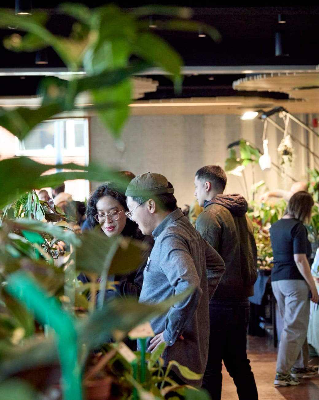 Twee bezoekers bekijken planten tussen het groen op de YouPlant Market